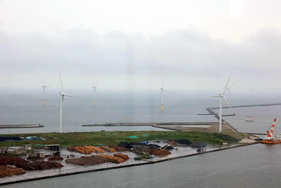 秋田港の洋上に設置された風車（奥）