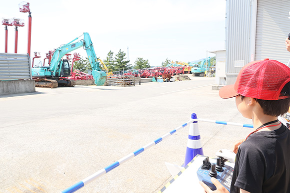 ラジコンでブームを遠隔操作。上手に動かせると、周囲から拍手と歓声が湧き起こった