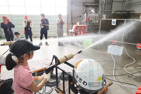 小型海水淡水化装置の水を使って、高圧洗浄機で射的を体験。大いに盛り上がった